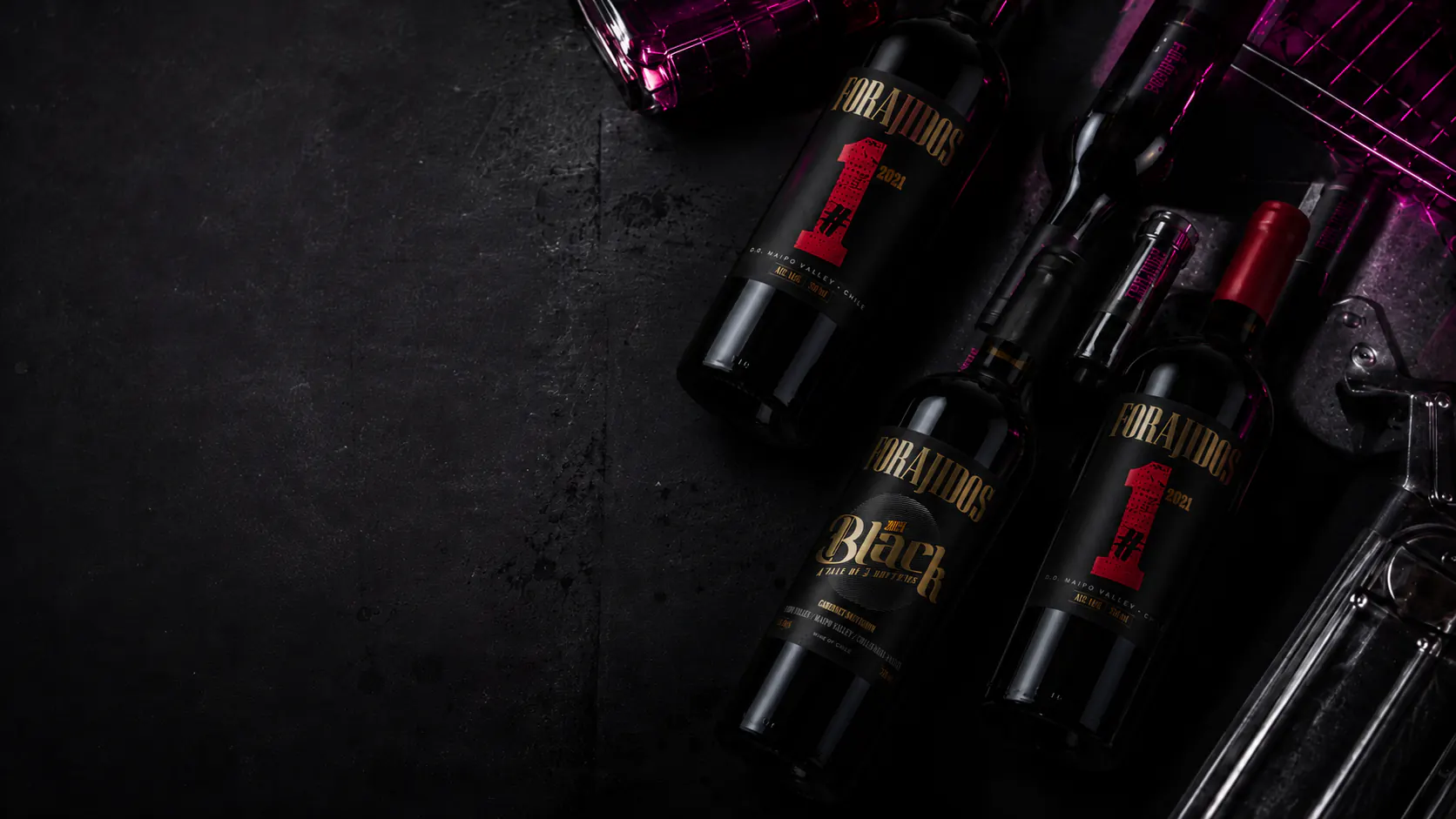 Botellas de vino Forajidos sobre una superficie negra