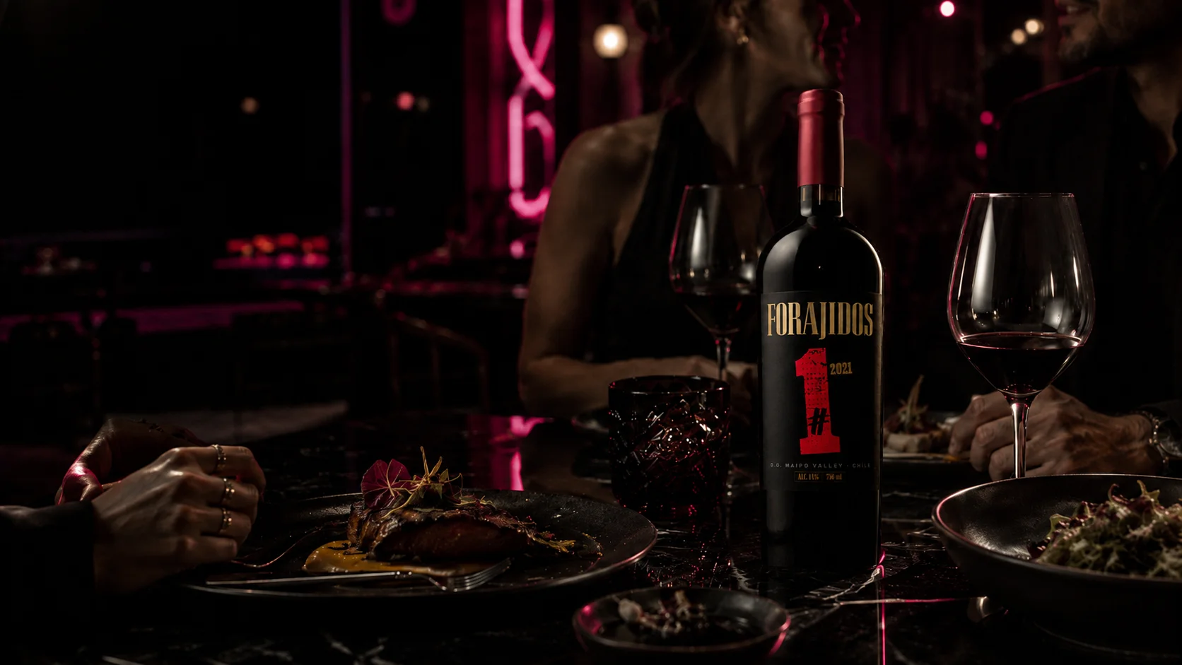 Botella de vino Forajidos en una mesa gastronómica nocturna